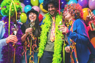 Wall Mural - Happy girls and boys at Carnival Party clinking glasses with champagne.