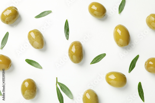 Fotomural Green olives and leaves on white background, top view