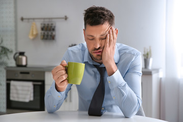 Sticker - Sleepy man with cup of drink at home in morning