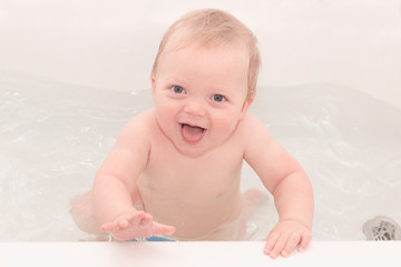 Looking into the camera taking bath 9 months toddler boy 