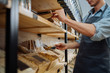 © Iryna - Mixed race male worker shop assistant filling paper bag with oat granola in bulk products in dispensers and food available at zero waste shop.