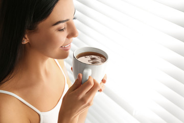 Sticker - Young woman with cup of tea near window. Lazy morning