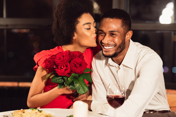 Girlfriend Kissing Boyfriend After Receiving Roses During Date In Restaurant