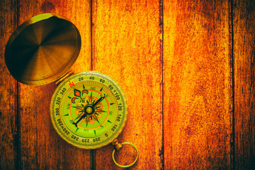an old compass on a wooden background