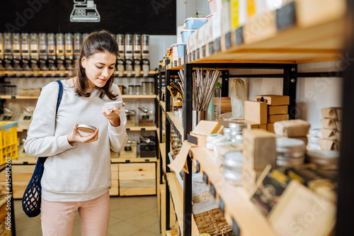 Cuadros en Lienzo Woman chooses and buys products in zero waste shop.