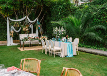 Decoration For Open Air Wedding Ceremony With Dinner Table In Blue And White Colors And Wedding Arch Setting On Garden With Green Tropical Plants