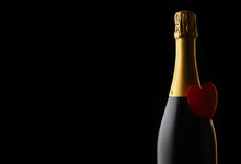 Closeup Of A Bottle Of Champagne With A Red Heart Against A Black Background With Copy Space.