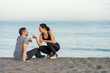 © Juan Alberto Ruiz/ADDICTIVE STOCK - Side view of cheerful young multiracial couple in sportswear sitting on sandy beach while resting after training and enjoying time together
