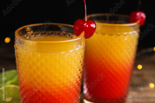 Fotomural Fresh alcoholic Tequila Sunrise cocktails on wooden table, closeup