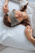 © LIGHTFIELD STUDIOS - top view of young woman in eye mask resting in bedroom
