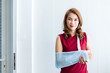 © Thinapob - Portrait of asian female patient in red dress broken arm after accident and wear arm splint for treatment and bed in the room hospital background,copy space