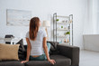 © LIGHTFIELD STUDIOS - dreamy young woman sitting on sofa in modern living room