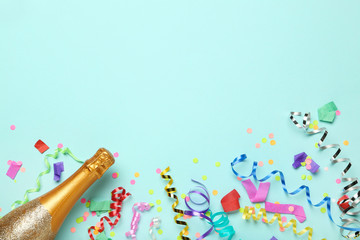 Wall Mural - Colorful ribbons with confetti and champagne bottle on blue background