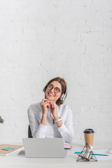 Wall Mural - dreamy businesswoman listening music in headphones while relaxing in office