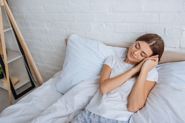 Wall Mural - attractive woman dreaming while lying on bed at home