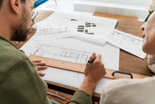 Crop View Of Two Architects Working Together At Desk In Office
