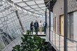 © Westend61 - Business people standing on skywalk in modern office building