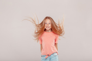 Wall Mural - Inclusive Beauty. Girl with freckles jumping isolated on grey smiling playful