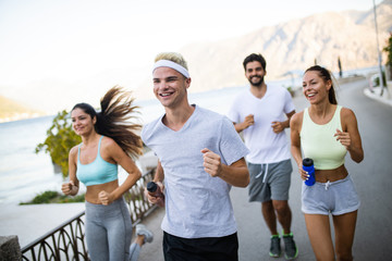 Outdoor portrait of group of friends running and jogging in nature