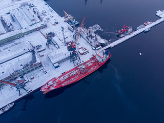 commercial north arctic port is loading containers onto cargo tanker ship. concept logistics and del