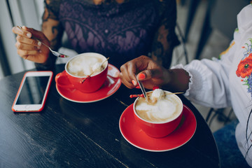 Girls in the cafe.Beautiful girls drinks coffee.Girls are sitting at the table