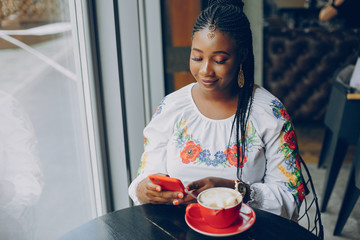 The girl in the cafe.Beautiful girl drinks coffee.The girl is sitting at the table