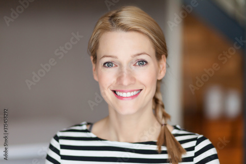 Close up Of A Smiling Caucasien blond woman in the living room Poster Mural XXL