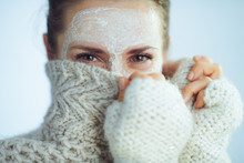 Elegant Woman With White Facial Mask Hiding Behind Clothes