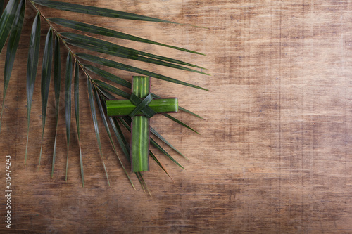 Fotomural Palm sunday concept: Cross shape of palm branch on an antique wooden background