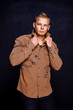 © zamuruev - man in a brown shirt on a black background.