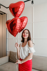 Wall Mural - woman with heart shaped balloons smiling and happy at home