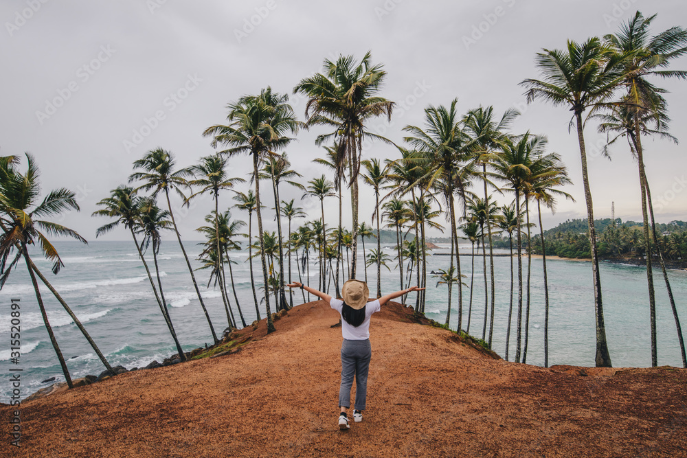 Yurist Foto Back view of young yourist woman visiting Coconut tree hill in ...