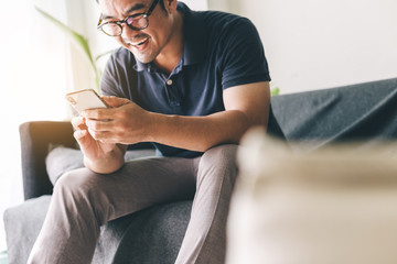 using cell phone.hand holding texting message on screen mobile chatting friend ,search internet information sitting on sofa in office.technology device contact communication connecting people concept