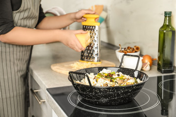 Canvas Print - Woman cooking delicious risotto, closeup. Tasty recipe