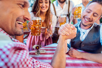 Wall Mural - Bavarian friends practicing the high art of arm wrestling