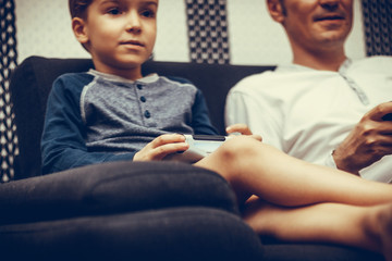 Close-up of kid playing video games with father.