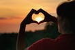 © Tunatura - Sillhouete of young woman making symbol of heart on the sky