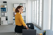 © contrastwerkstatt - Businesswoman perched on the edge of her desk