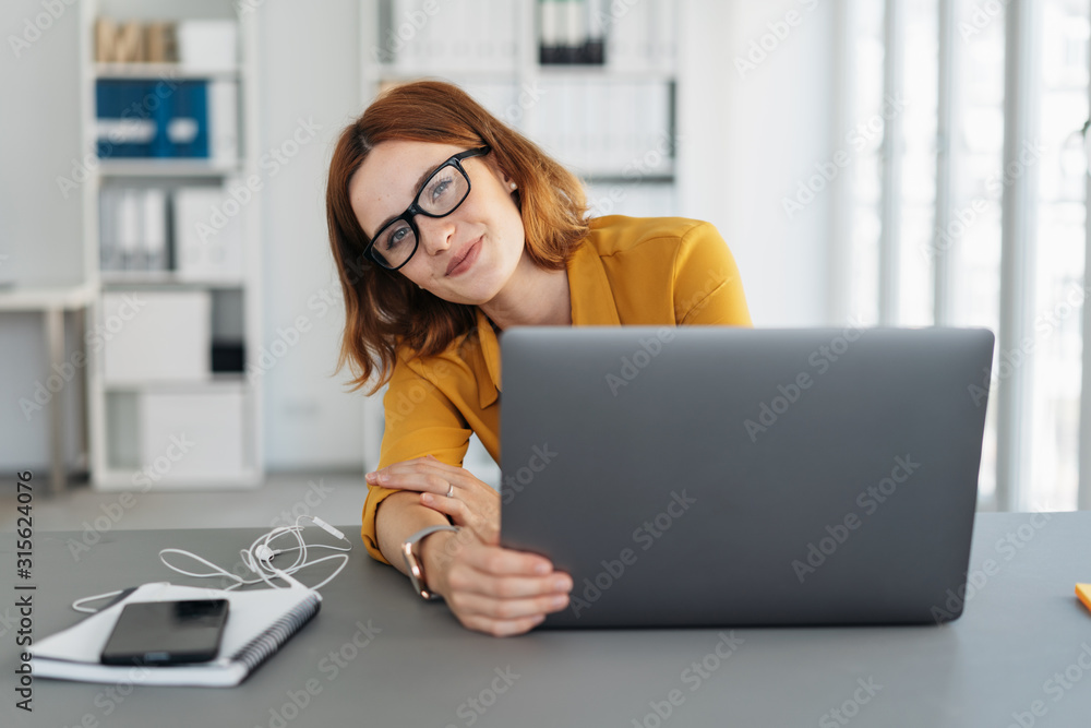 Amused businesswoman peering around her laptop - obrazy, fototapety, plakaty 
