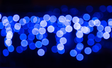 Black background with blur blue and white light round spots. Abstract defocused bulbs pattern