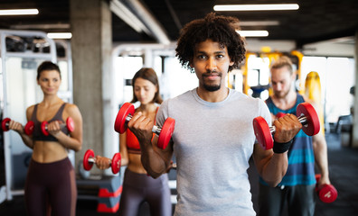 Attractive sports people are working out in gym