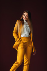 Wall Mural - beautiful girl in a yellow suit smiles. casual clothes for busin