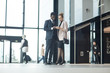 © AnnaStills - Business couple working online on their mobile phones while standing at the office building