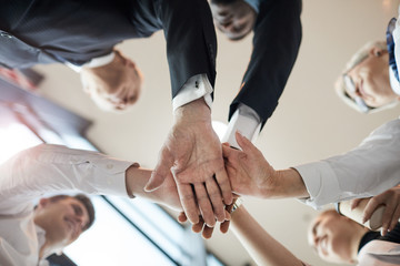 Wall Mural - Close-up of business people standing in circle and holding hands they supporting each other during team work