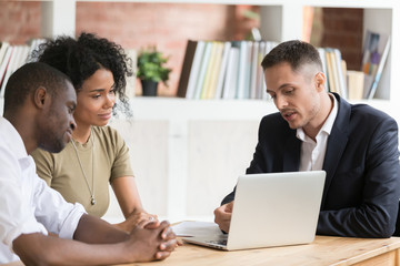 Caucasian realtor meeting with clients couple show houses at laptop