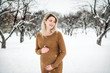 © Louis-Photo - Young happy pregnant woman in snowy forest