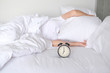 © BoszyArtis - Woman sleep on the bed turns off the alarm clock wake up at the morning, Selective focus..