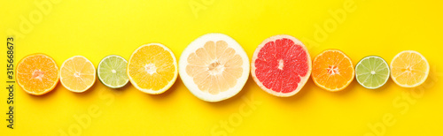 Fotografía Flat lay with citrus fruits on yellow background, space for text