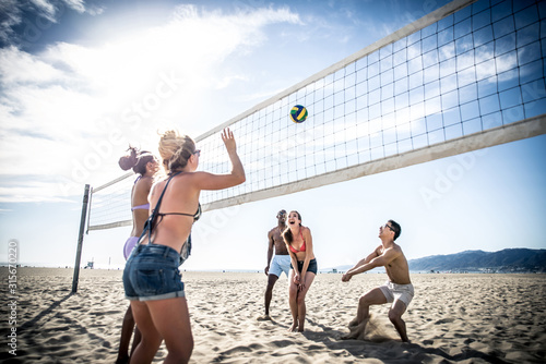 Plakaty piłka plażowa  grupa-przyjaciol-grajaca-w-siatkowke-plazowa-na-plazy-i-dobrze-sie-bawiaca
