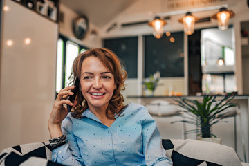 Poster - Cheerful woman talking on the phone at home, portrait, close-up.